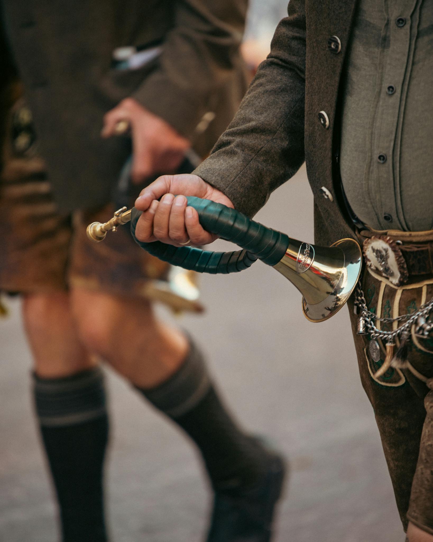 Musicians in traditional Bavarian attire playing wind instruments at Oktoberfest in Munich.